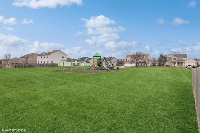 view of yard featuring playground community, fence, and a residential view