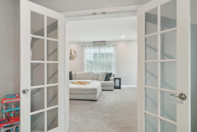 carpeted living area featuring recessed lighting, french doors, and baseboards