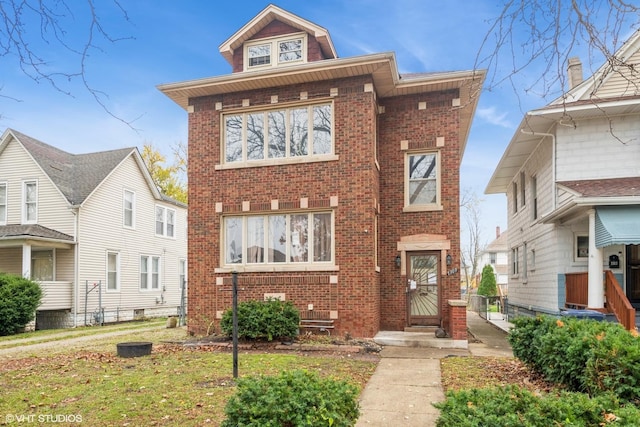 view of front facade with a front yard and brick siding