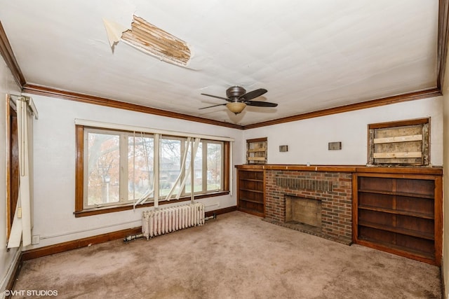 unfurnished living room featuring ceiling fan, light colored carpet, ornamental molding, a brick fireplace, and radiator