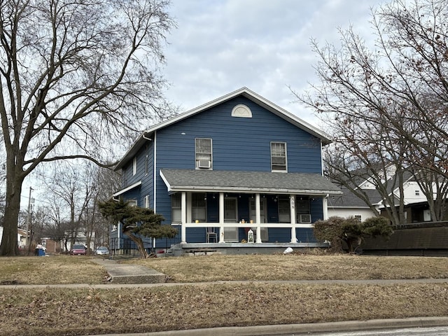 traditional-style home with covered porch and a front lawn