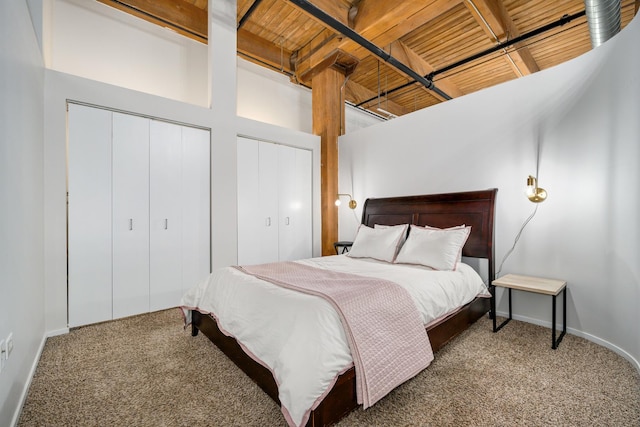 bedroom featuring carpet flooring, baseboards, and two closets