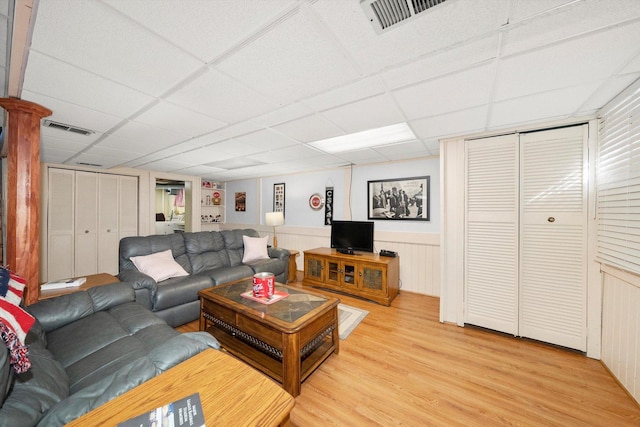 living room featuring visible vents, light wood-type flooring, and a drop ceiling