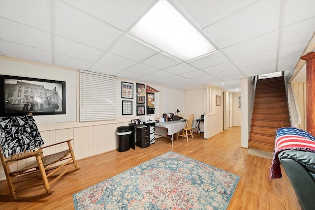 home office with light wood-style flooring and a paneled ceiling