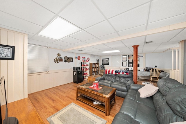 living room with visible vents, a paneled ceiling, a wainscoted wall, and wood finished floors