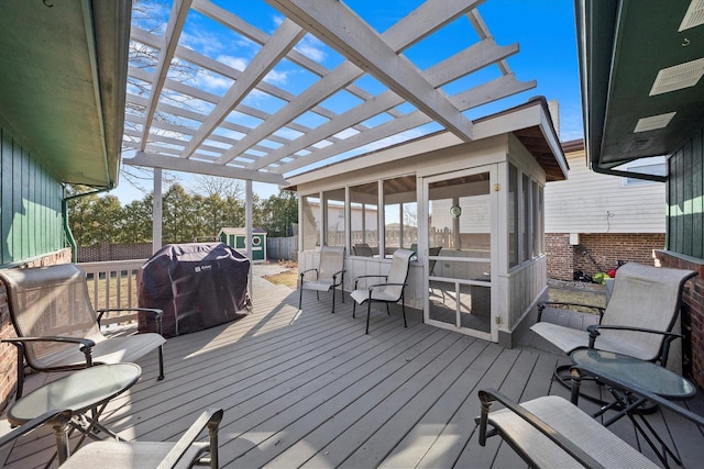 wooden deck with an outdoor structure, area for grilling, a pergola, and a sunroom