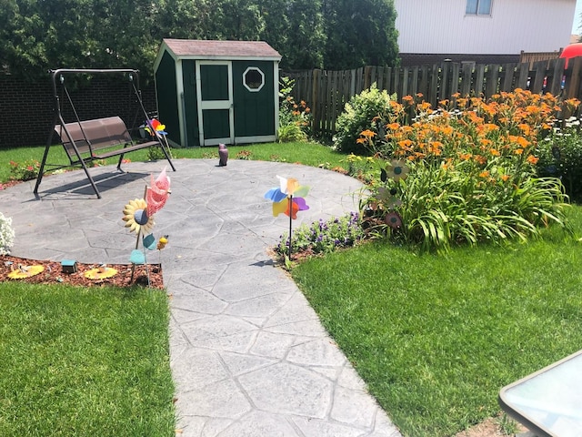 view of yard with a patio area, an outdoor structure, a storage shed, and a fenced backyard