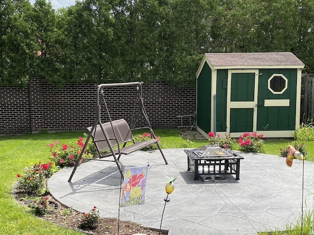 view of patio / terrace featuring an outbuilding, a storage unit, and a fenced backyard