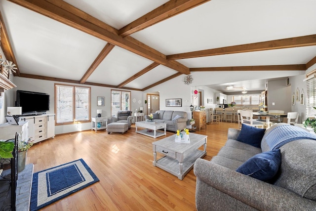 living room with lofted ceiling with beams and light wood finished floors