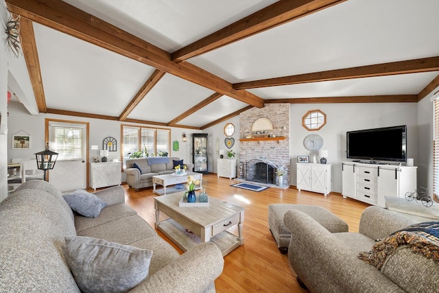 living area with light wood finished floors, a fireplace, and lofted ceiling with beams