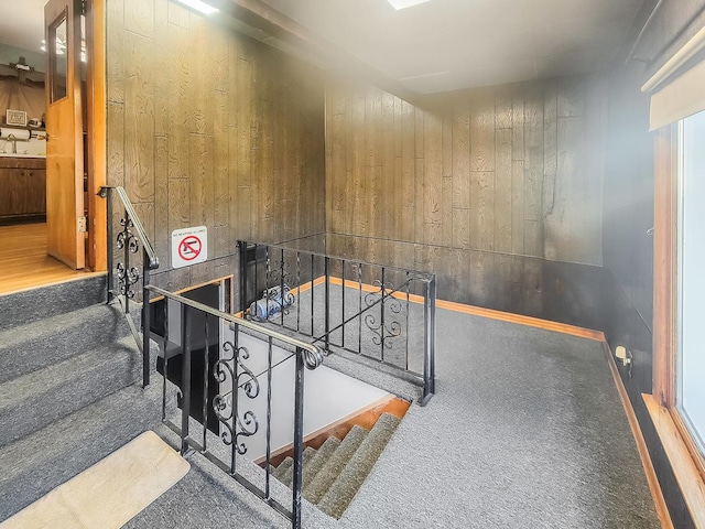 staircase featuring wooden walls