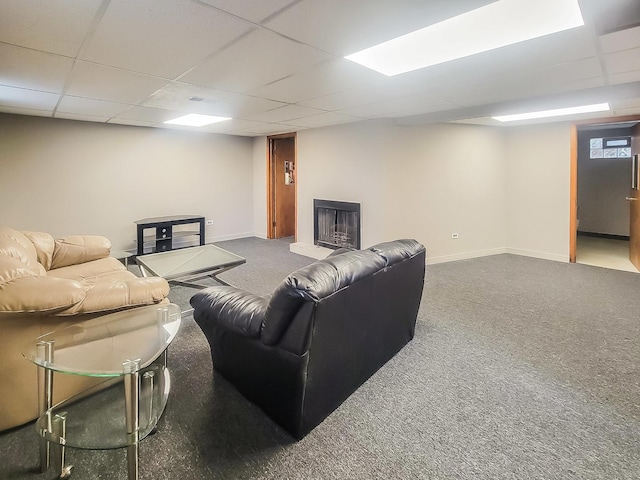 living area featuring carpet flooring, a paneled ceiling, and baseboards