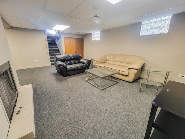 living room featuring a paneled ceiling, carpet floors, a healthy amount of sunlight, stairs, and baseboards