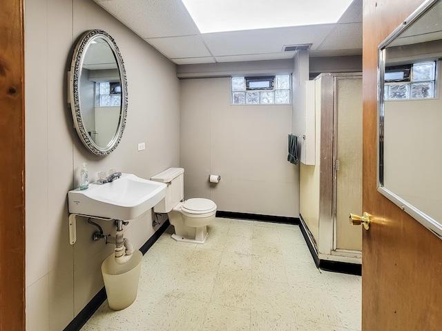 bathroom featuring a drop ceiling, toilet, visible vents, baseboards, and tile patterned floors