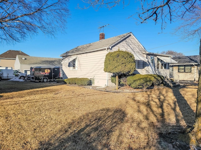 view of home's exterior featuring a yard and a chimney