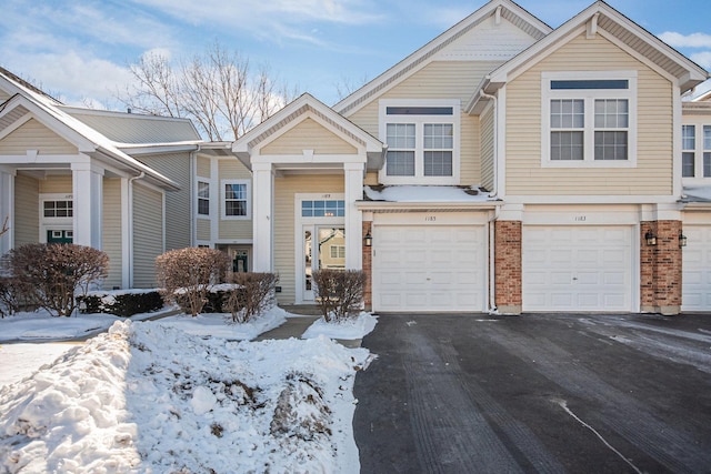 view of front of home featuring driveway, brick siding, and an attached garage