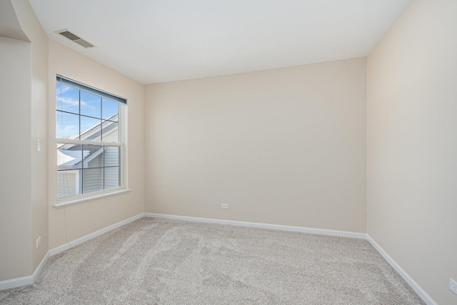 empty room featuring light carpet, visible vents, and baseboards