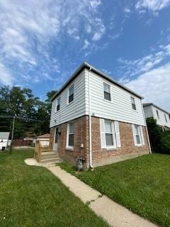 view of side of property with a lawn and brick siding