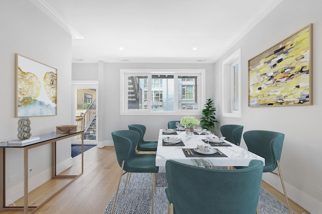 dining room with recessed lighting, light wood-style flooring, ornamental molding, baseboards, and stairs