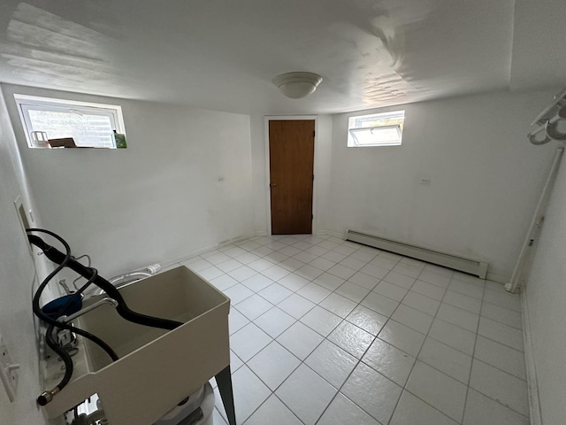 basement with light tile patterned floors and baseboard heating