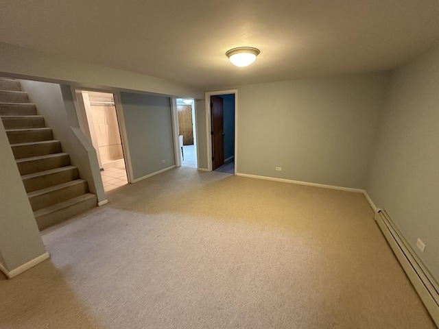 finished basement with stairs, baseboards, baseboard heating, and light colored carpet