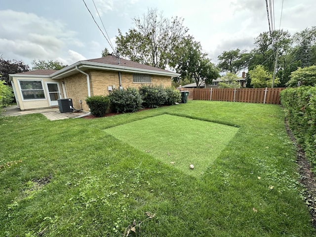 view of yard featuring central AC, fence, and a patio