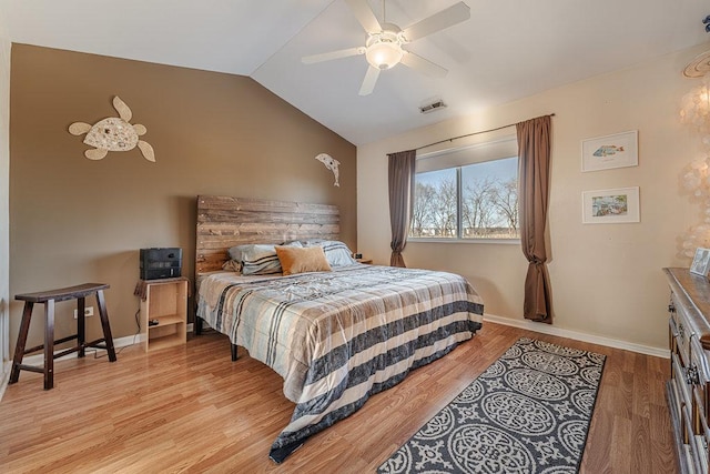 bedroom with lofted ceiling, baseboards, visible vents, and light wood-style floors