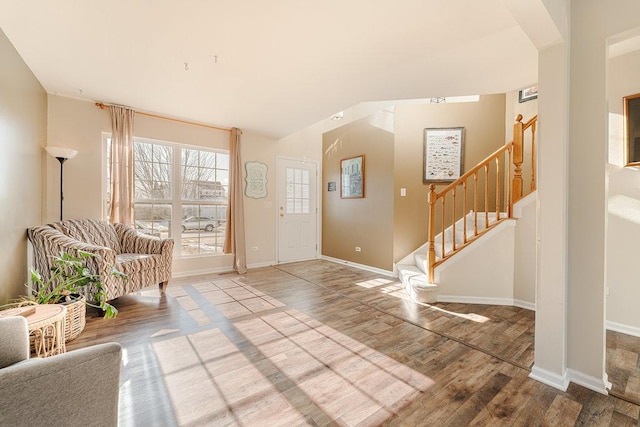 foyer with stairs, baseboards, and wood finished floors