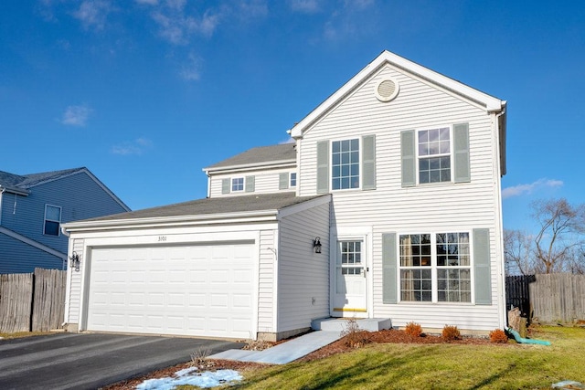 traditional-style home with a garage, aphalt driveway, a front yard, and fence