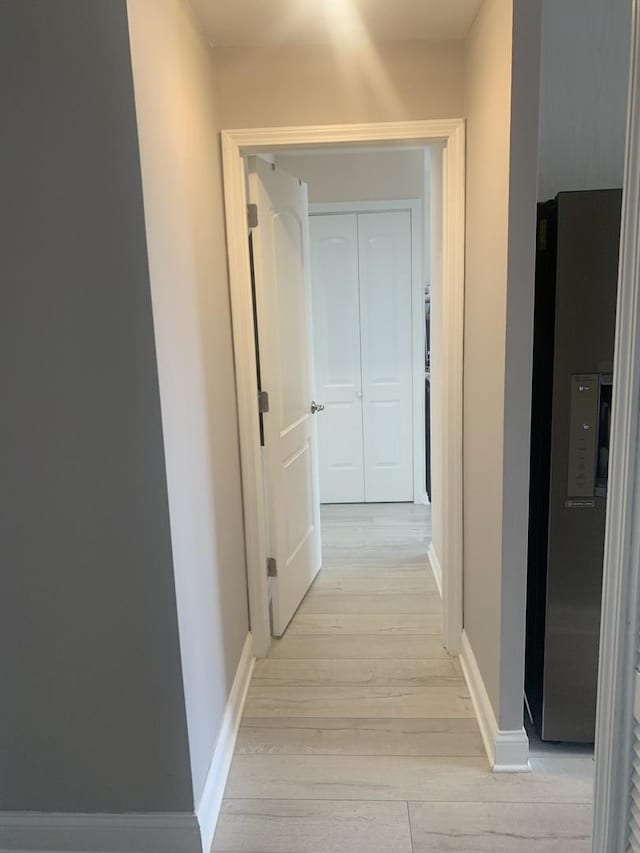 hallway with baseboards and light wood finished floors