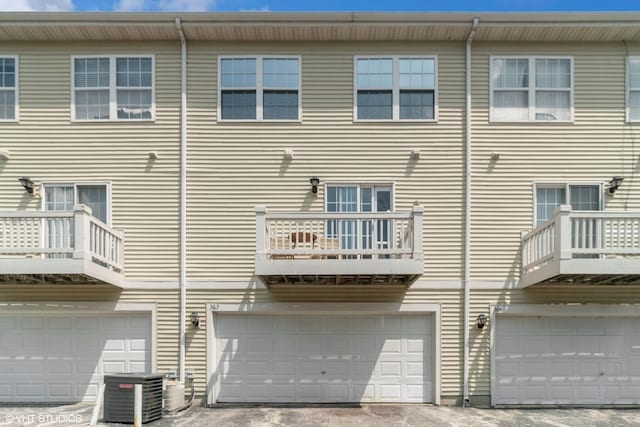 back of house featuring central AC unit and an attached garage