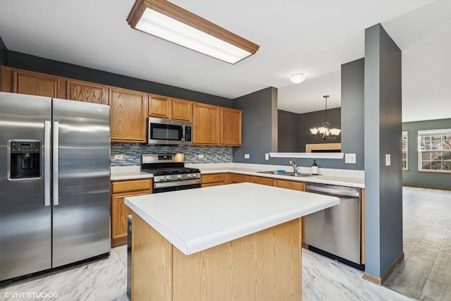 kitchen with a sink, stainless steel appliances, marble finish floor, and light countertops