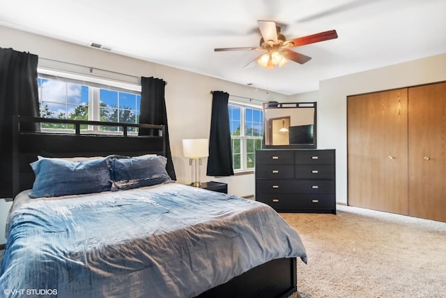 bedroom featuring visible vents, carpet, a closet, and ceiling fan