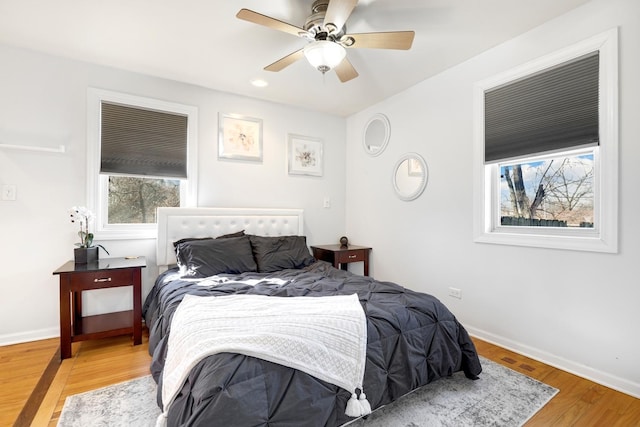 bedroom with a ceiling fan, baseboards, and wood finished floors