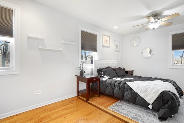 bedroom featuring a ceiling fan, baseboards, and wood finished floors