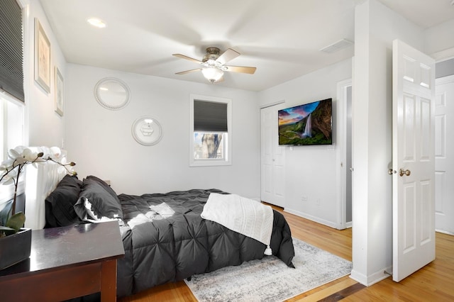 bedroom with visible vents, baseboards, ceiling fan, and wood finished floors