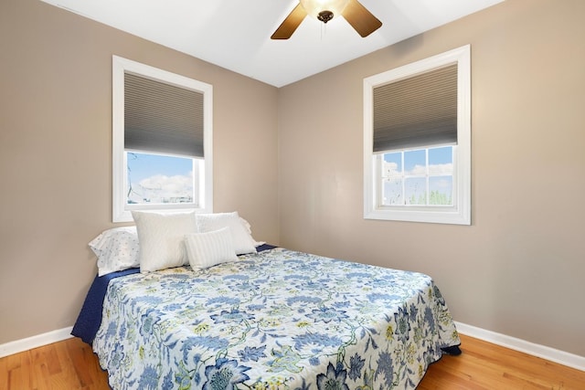 bedroom with ceiling fan, baseboards, and wood finished floors