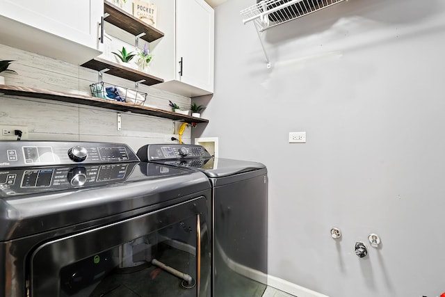 washroom featuring washing machine and dryer, cabinet space, and baseboards