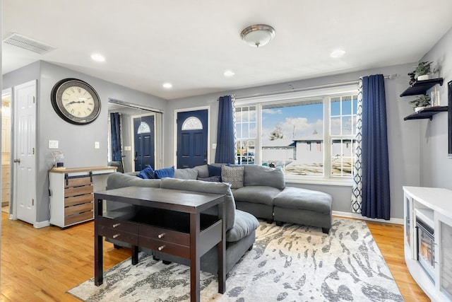 living room with baseboards, recessed lighting, visible vents, and light wood-style floors