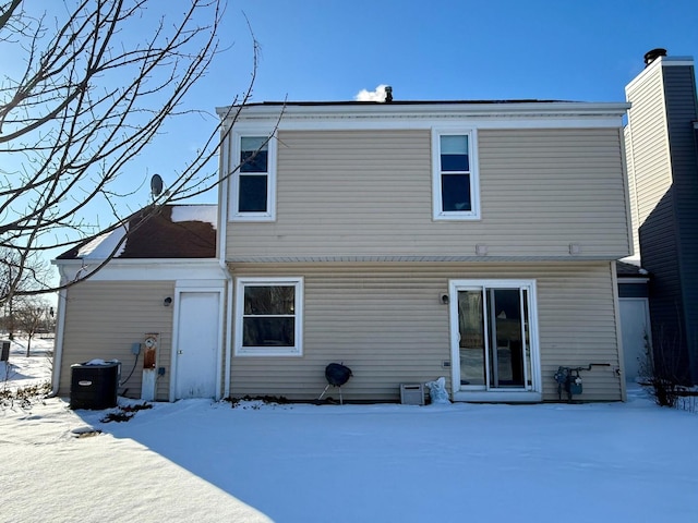 snow covered house featuring central air condition unit