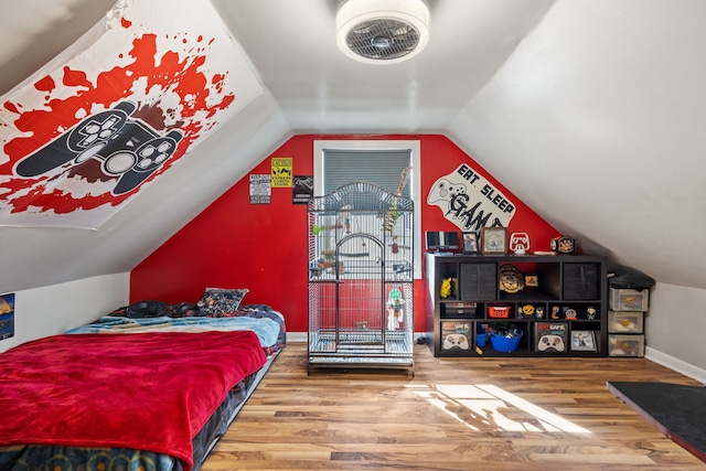 bedroom with vaulted ceiling, baseboards, and wood finished floors