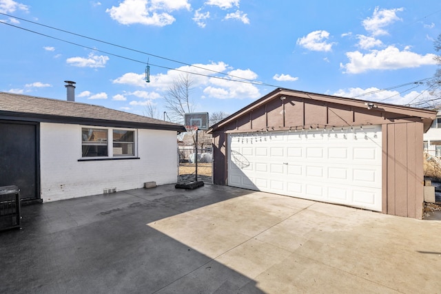 view of side of property with a garage, brick siding, an outdoor structure, and a shingled roof