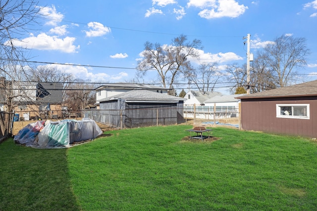 view of yard featuring fence, a fenced in pool, and a fire pit