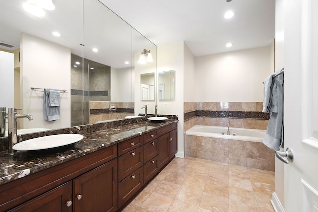 bathroom with a sink, a garden tub, recessed lighting, and double vanity