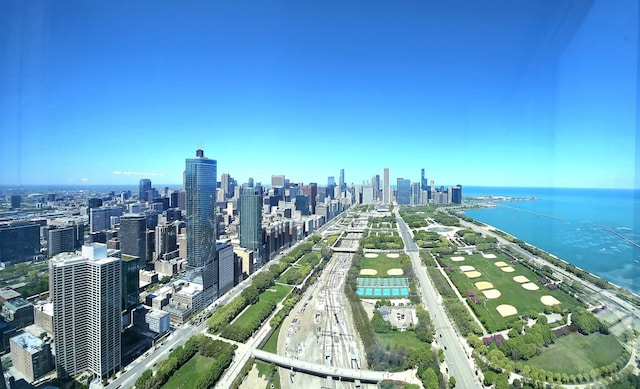 drone / aerial view of a highway, a large body of water, and a view of skyline