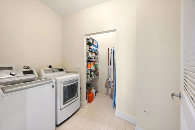 laundry room featuring light tile patterned floors, laundry area, washer and dryer, and baseboards