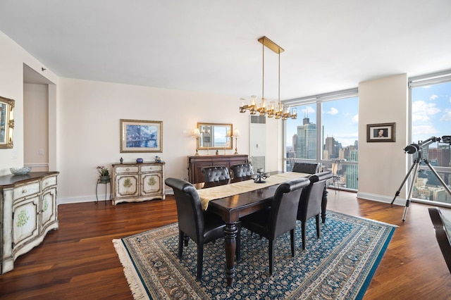 dining area with baseboards, an inviting chandelier, dark wood-style flooring, floor to ceiling windows, and a city view