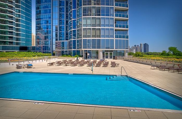 community pool featuring a patio and a view of city
