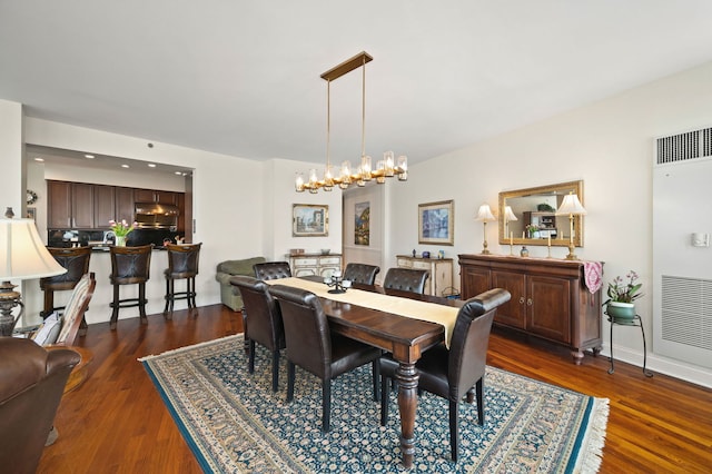 dining area featuring visible vents, an inviting chandelier, and dark wood-style flooring