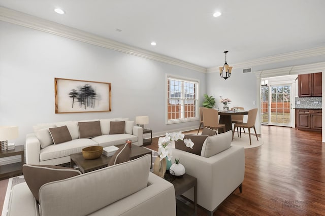 living room with crown molding, plenty of natural light, visible vents, and dark wood finished floors